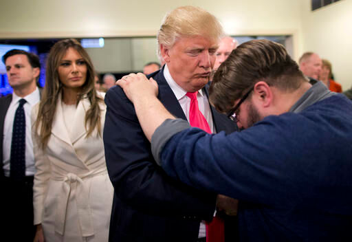 In this Jan. 31, 2016, file photo, Pastor Joshua Nink, right, prays for Republican presidential candidate Donald Trump, as his wife, Melania, left, watches after a Sunday service at First Christian Church, in Council Bluffs, Iowa. Trump's candidacy has put a harsh spotlight on the fractures among Christian conservatives, most prominently the rift between old guard religious right leaders who backed the GOP nominee as an ally on abortion, and a comparatively younger generation who considered his personal conduct and rhetoric morally abhorrent.