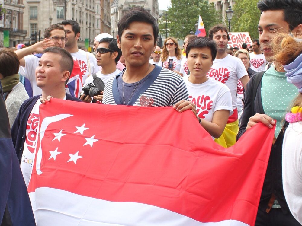 People holding up the Singaporean flag and marching with it