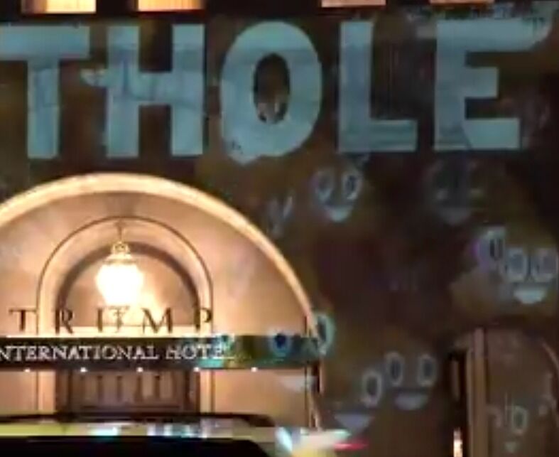 An activist projects &#8216;s**thole&#8217; &#038; poop emojis on Trump&#8217;s hotel