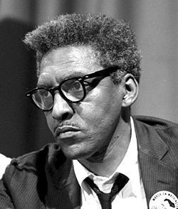 Bayard Rustin at news briefing on the Civil Rights March on Washington in the Statler Hotel, half-length portrait, seated at table