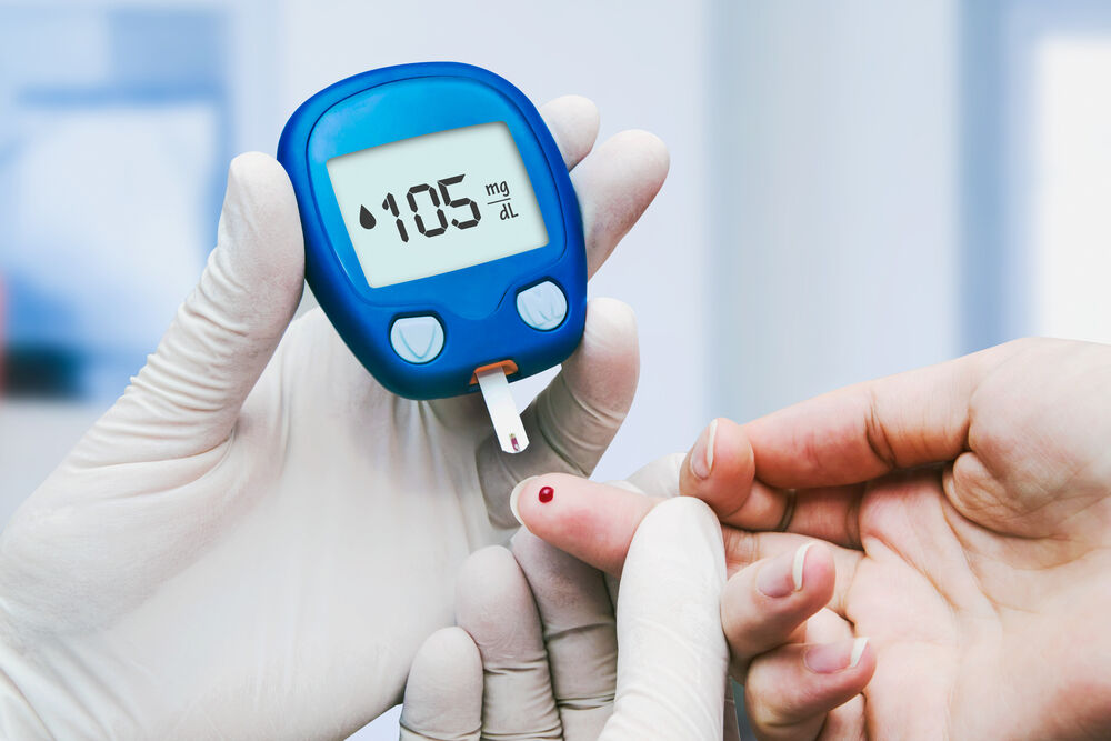 Doctor making blood sugar test in clinic for diabetes.