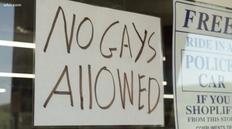 Sign on a store window reading "NO GAYS ALLOWED"