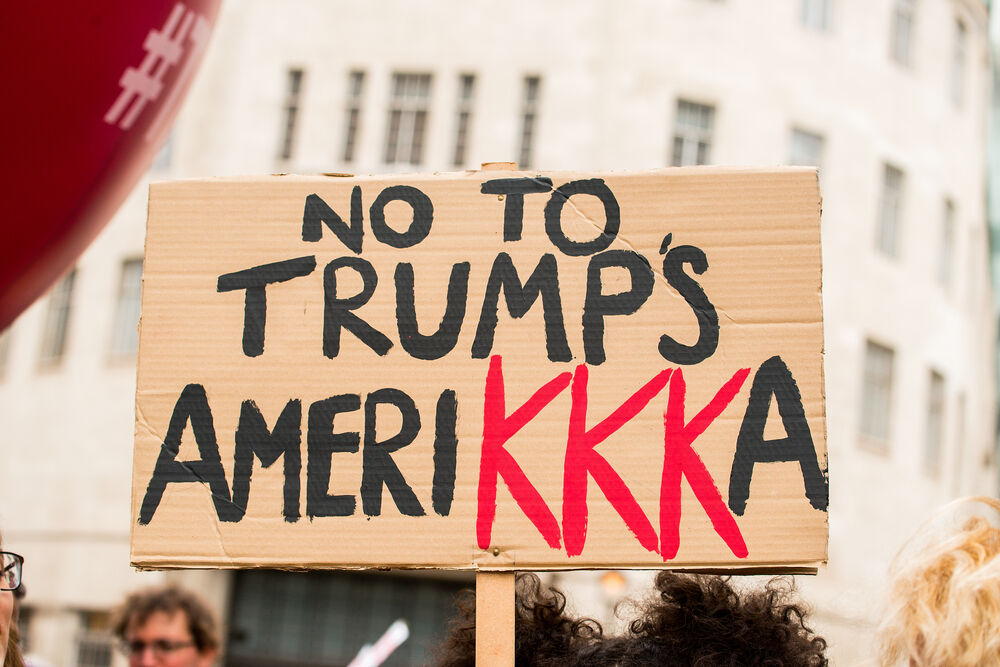 Protest sign reading "No to Trump's Amerikkka"