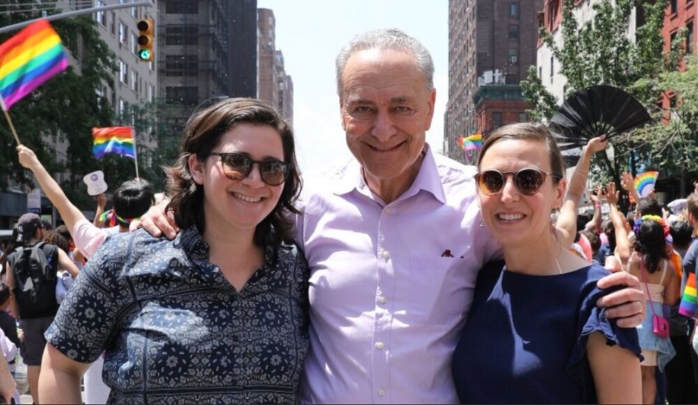 NY Senator Chuck Schumer embraces his daughter and her fiancee at the NYC Pride Parade.