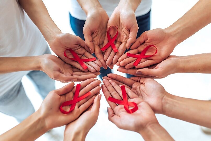 Group of young multiracial woman with red ribbons in hands are struggling against HIV/AIDS.