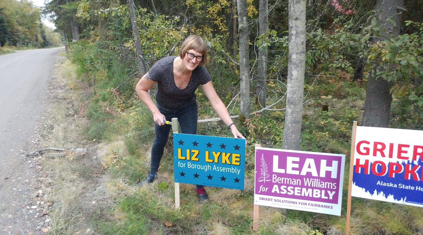 Liz Lyke poses with a yard sign.