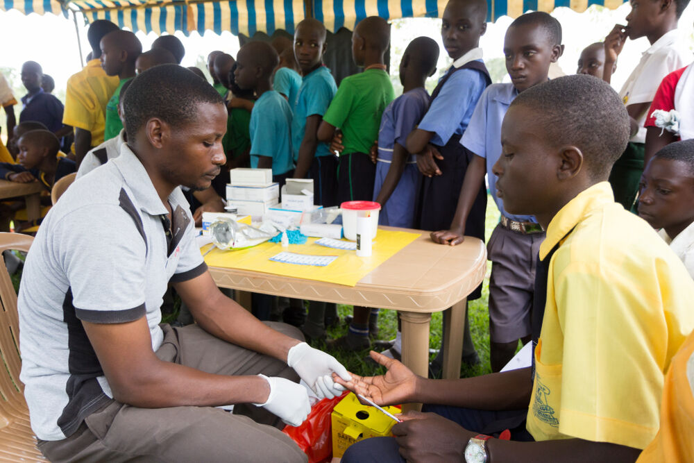 Nkokonjeru, Uganda June 22 2017: A health worker tests a boy for HIV.