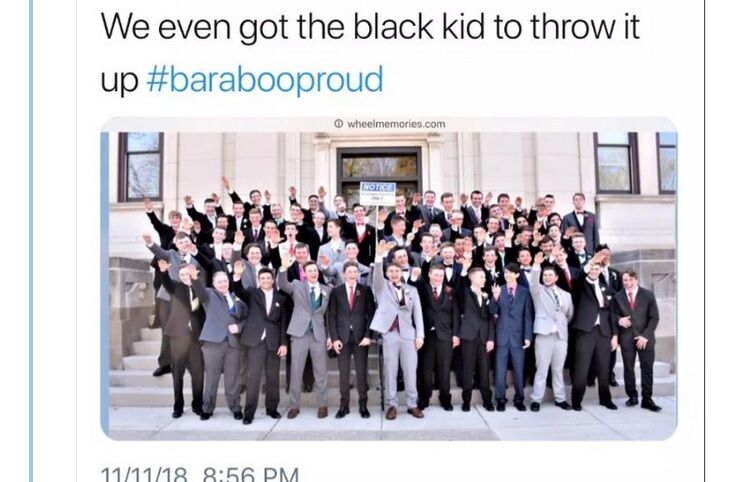 A screenshot of a tweet with a picture of a group of white teenagers holding up one arm