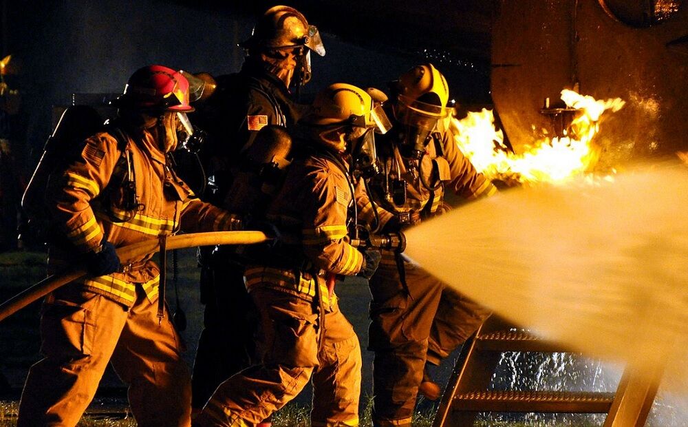 Firefighters holding a hose in a demonstration.