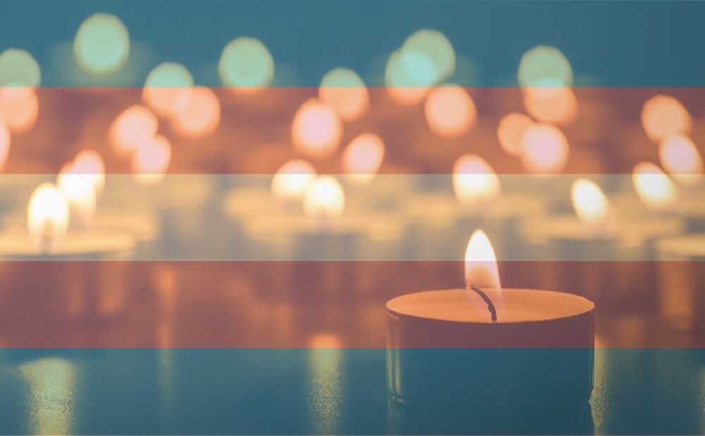 Memorial candles with the trans flag overlayed