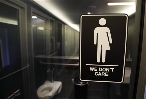 A bathroom with a "We don't care" sign on it that has a bi-gender stick figure.