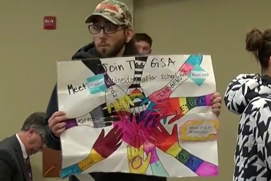 A man in a cap holding a GSA poster