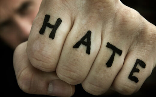 "HATE" written on someone's fist.