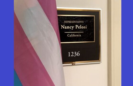 Transgender flag next to a sign for the office of Nancy Pelosi