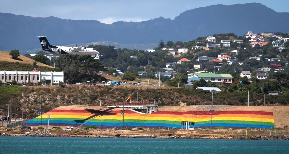 The giant rainbow flag with Wellington in the background and the shadow of an airplane