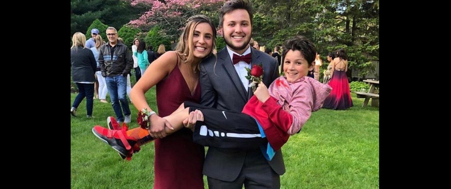 Nicholas Bulman and his prom date and field hockey teammate Abby Al-Asousi pose with her younger brother.