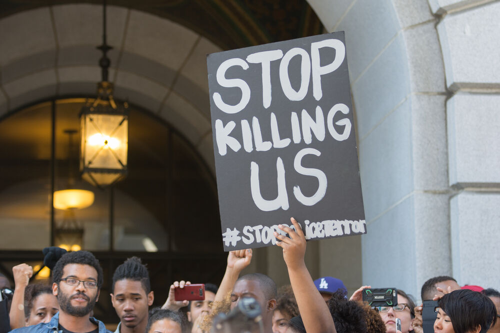 July 12, 2016 - Black Lives Matter protestors holding a poster during a march on City Hall following the fatal shooting of African American female Redel Jones by LAPD.