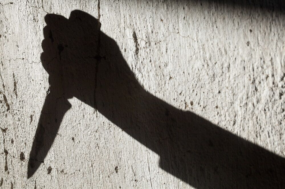 A shadow of a hand with a knife