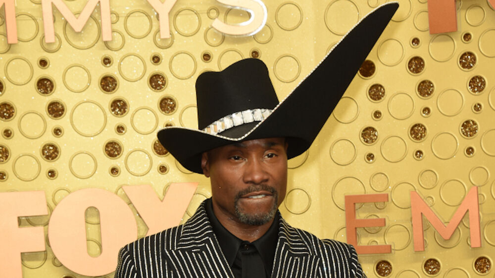 Billy Porter wears a hat with a wide upward-angles brim on the left side.