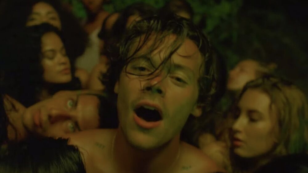 Harry Styles gets caressed by men and women in his new video for the allegedly bisexual anthem "Lights Up"