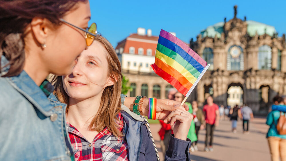 Two young women hold a rainbow flag