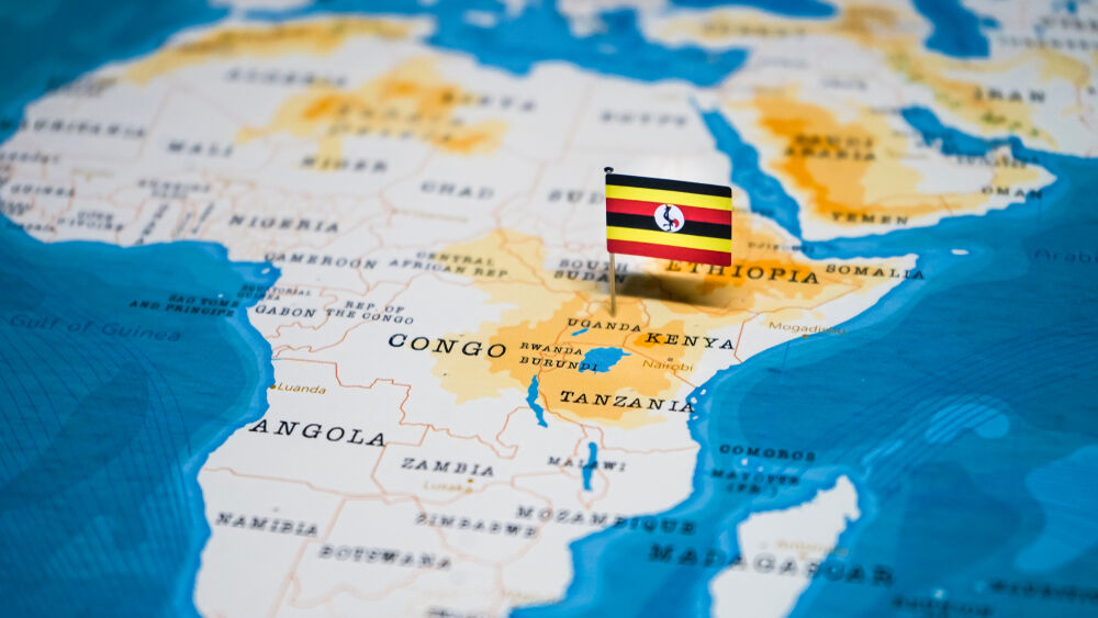 A Ugandan flag placed on the country in an African map