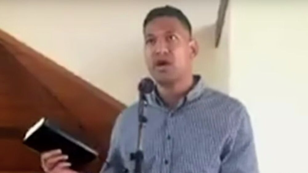 Israel Folau delivers a sermon while holding a bible.