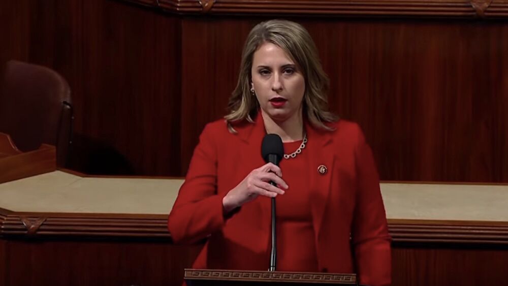 Former Democratic Rep. Katie Hill announces her resignation in the U.S. House chamber wearing a red suit.