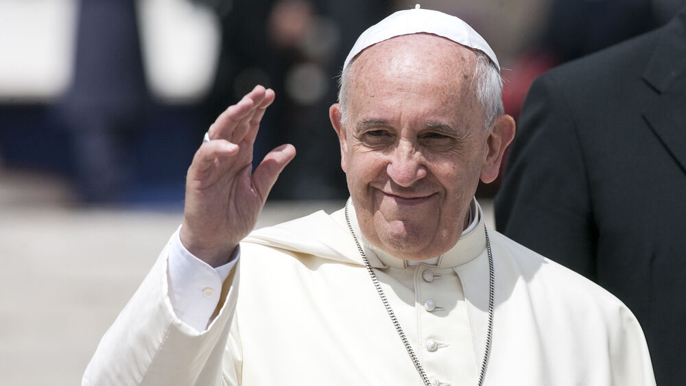 Pope Francis smiles and waves to his congregants.