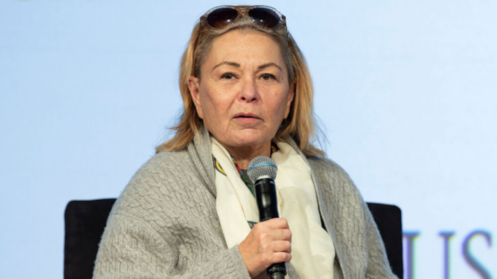 Roseanna Barr speaks to an audience using a microphone.