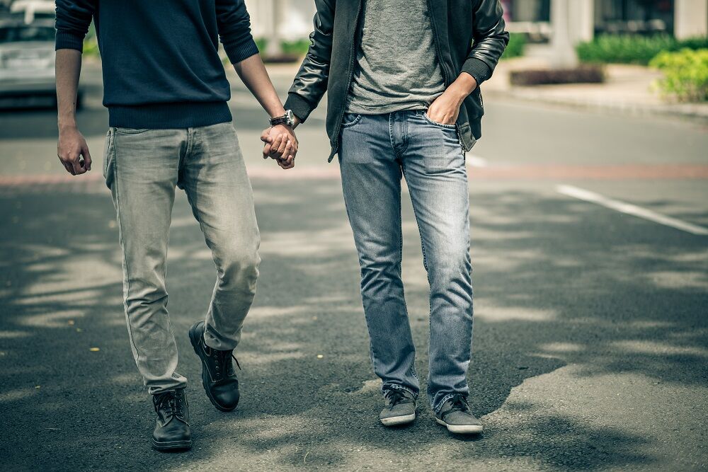 Two men holding hands in the street