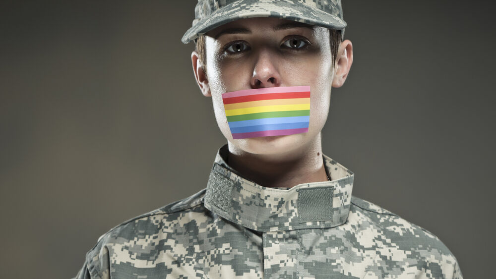 A soldier has a rainbow flag sticker covering their mouth.