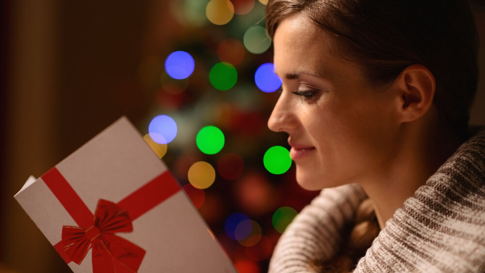 Young woman reading Christmas postcard