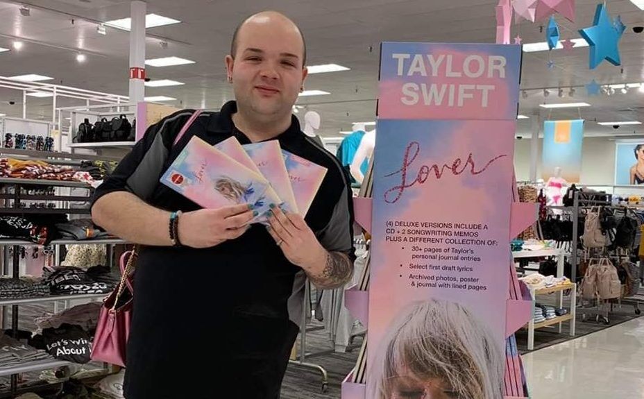 Michigan hairstylist and college student Kevin Bacon, posing with a warehouse store cutout of Taylor Swift.