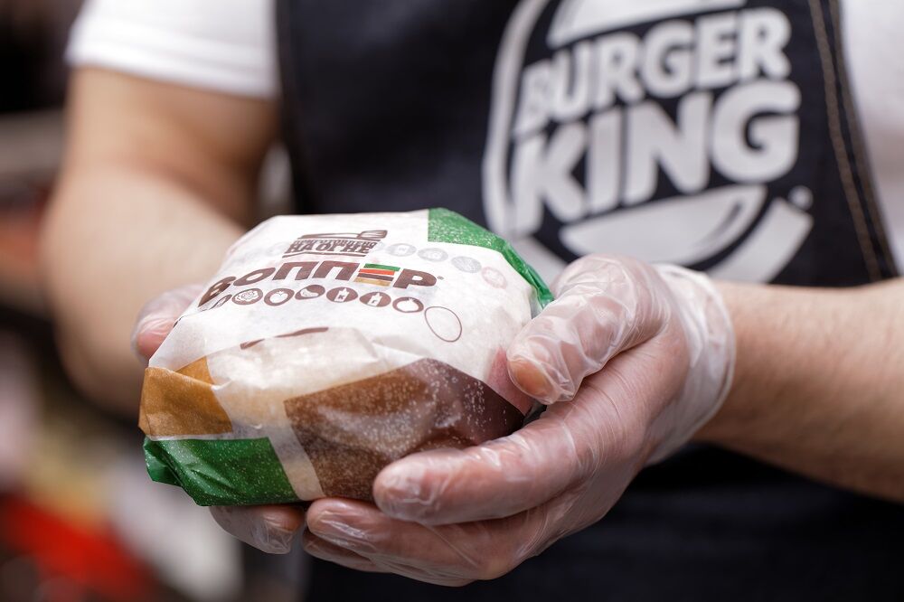 Burger King worker holding a hamburger