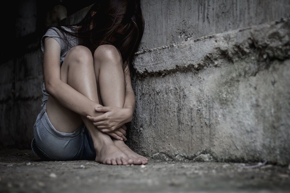 A girl huddled in a corner in fear