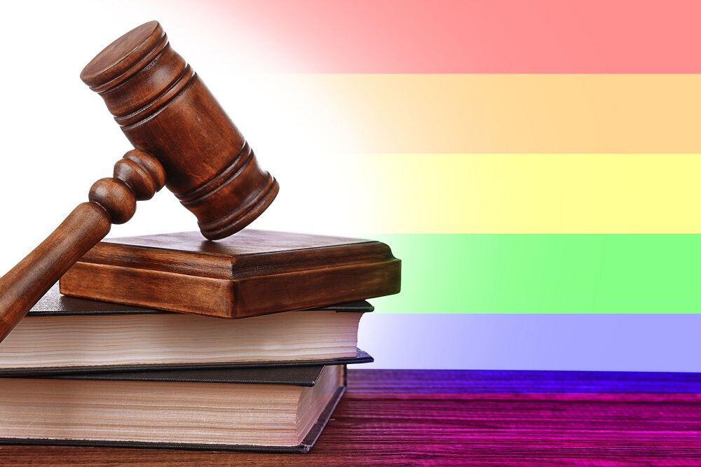 A gavel in front of a rainbow flag