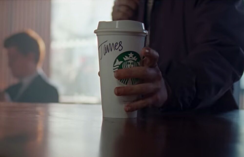James grabs the Starbucks cup with his name on it