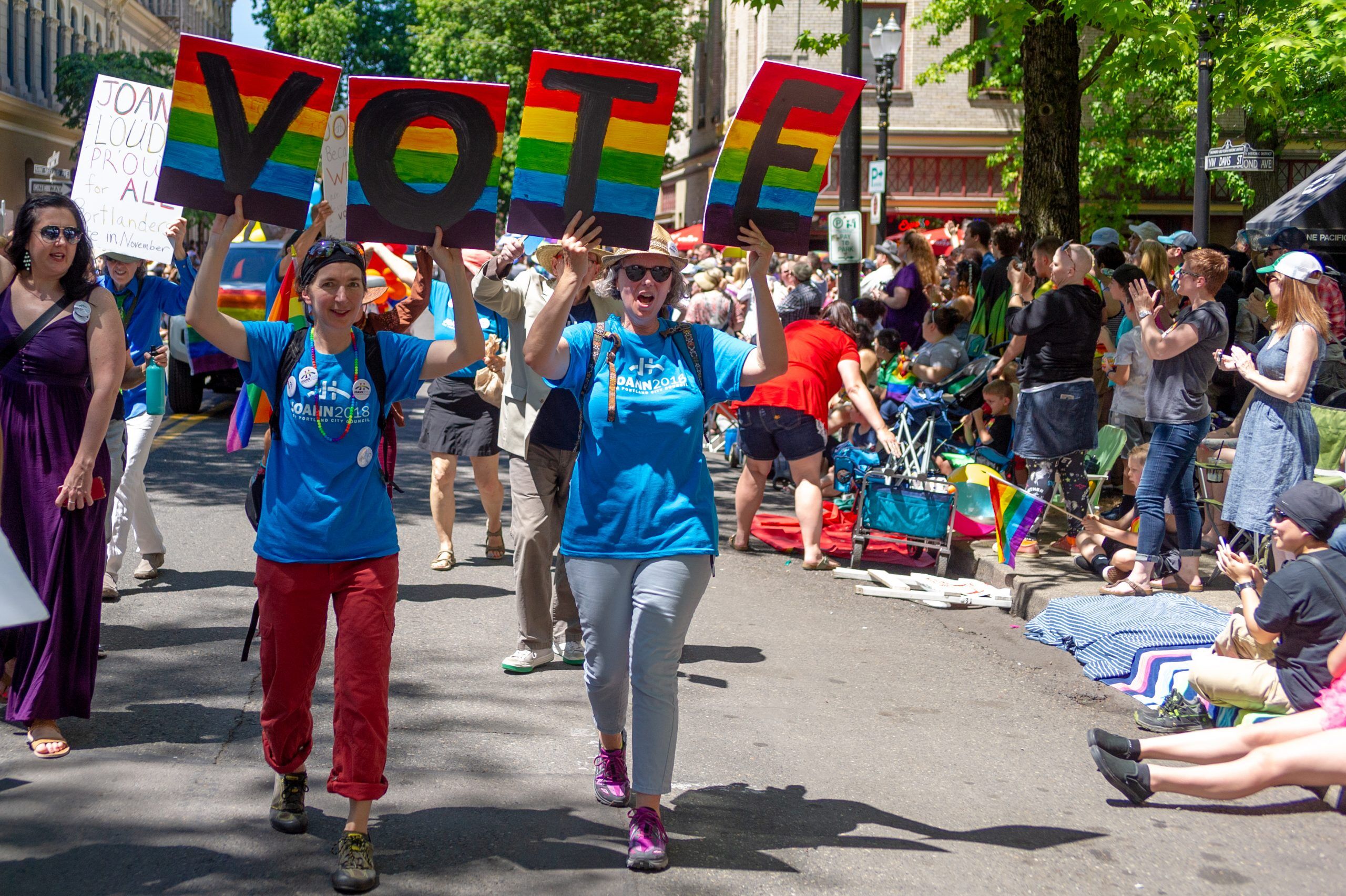 Two women urge LGBTQ people to vote in the next election during the 2018 pride parade in Portland, Oregon.