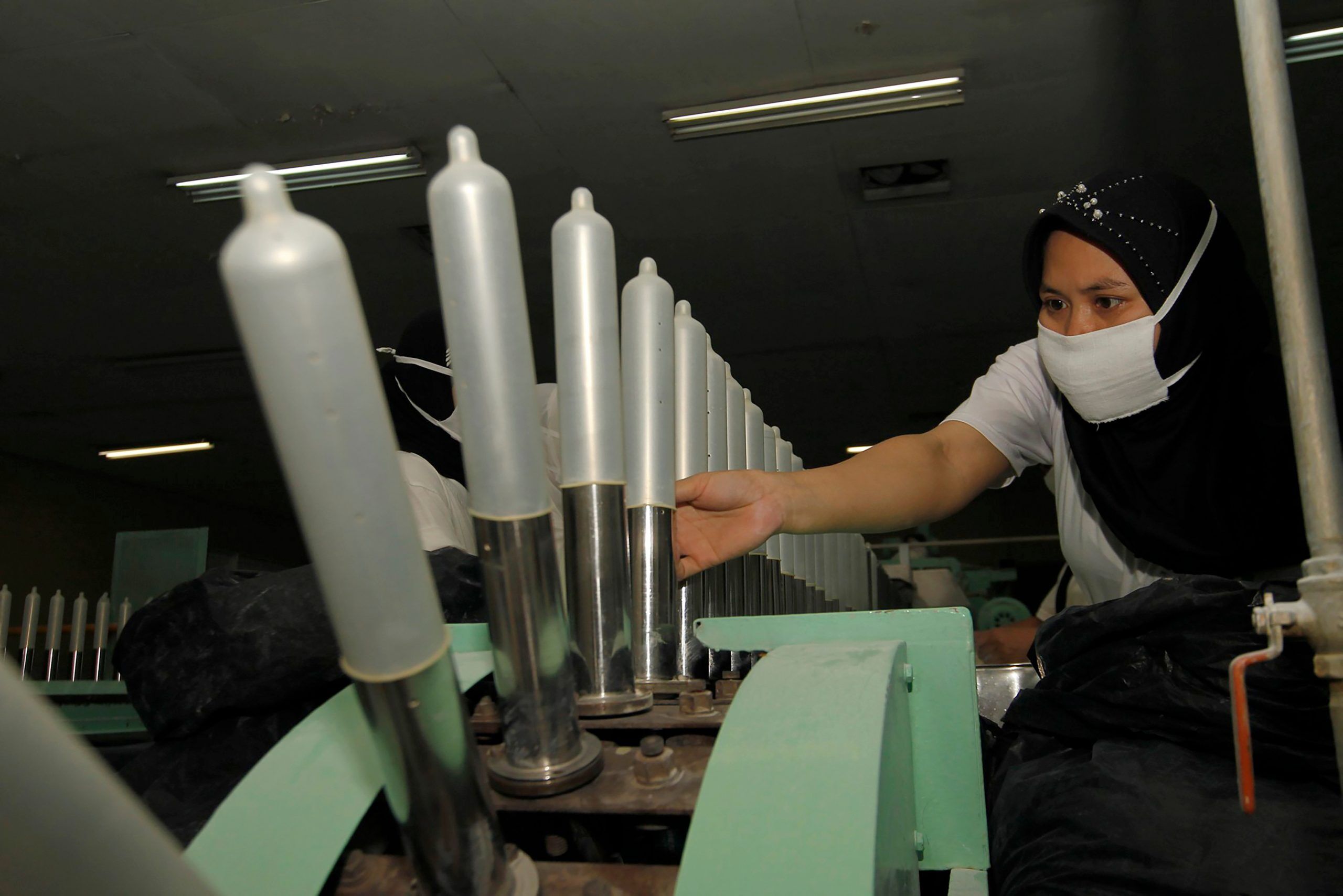 A worker inspects finished condoms at a factory in Bandung, Indonesia.