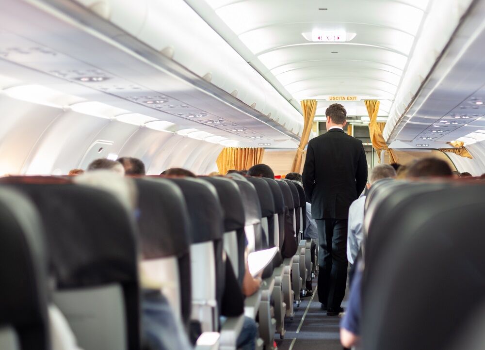 Flight attendant walking down an aisle