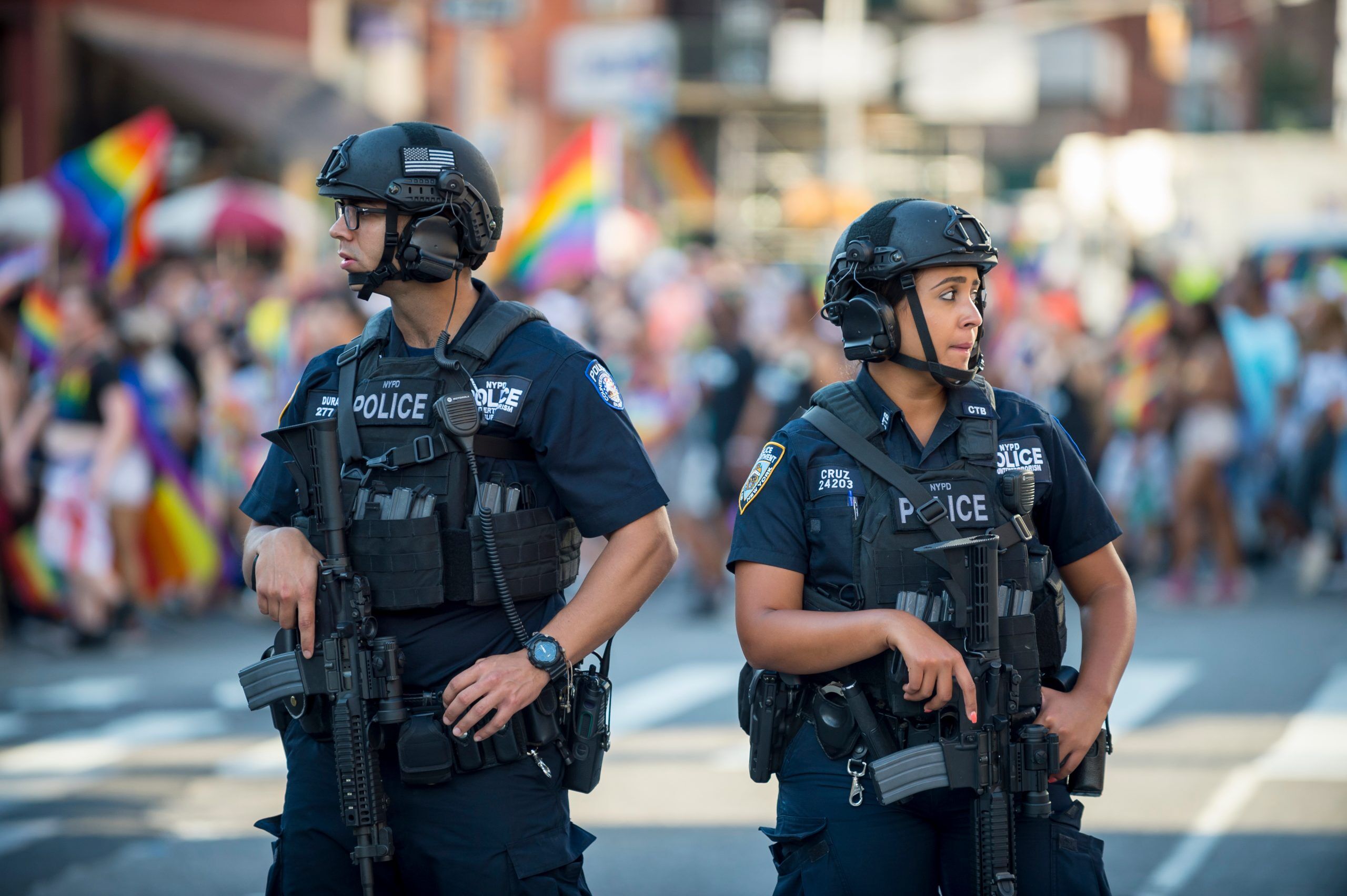 JUNE 25, 2017: NYPD police officers stand with hands on their weapons, providing security on the sidelines of the annual Gay Pride parade as it passes through Greenwich Village.
