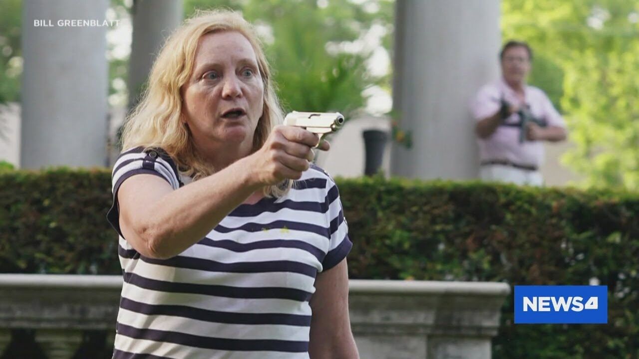 Patricia McCloskey holds a gun on a group of protestors passing by her home