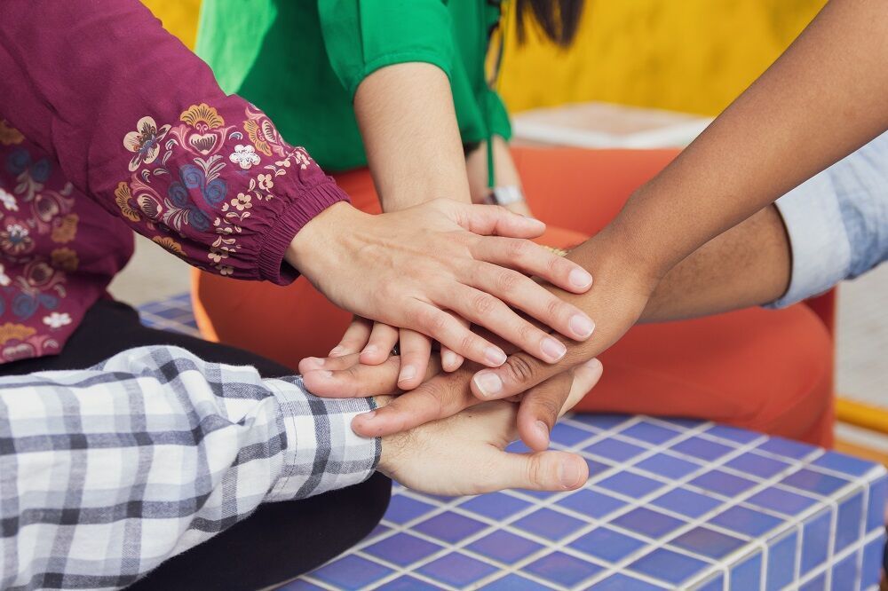 Hands of different skin tones together