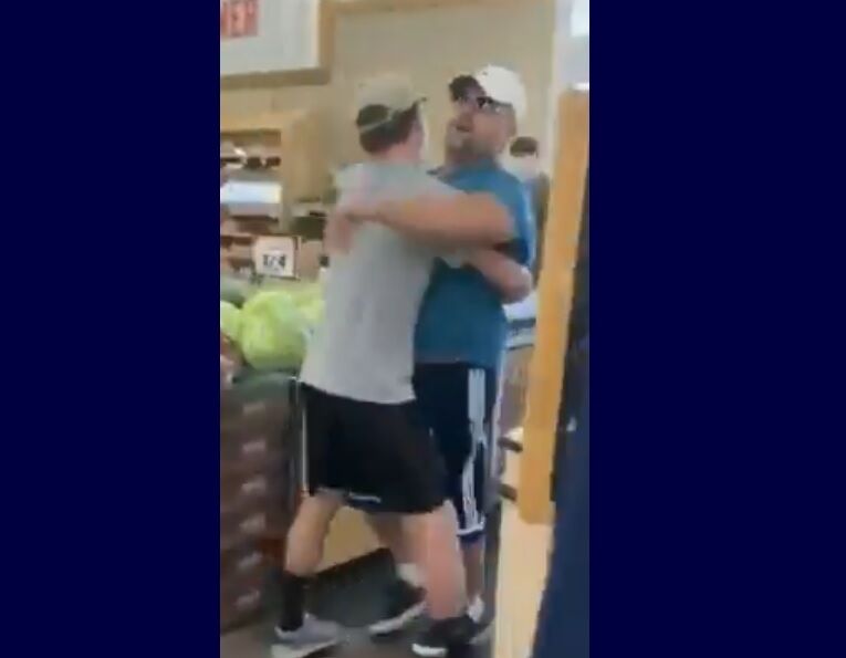 The man being restrained and carried by his son.