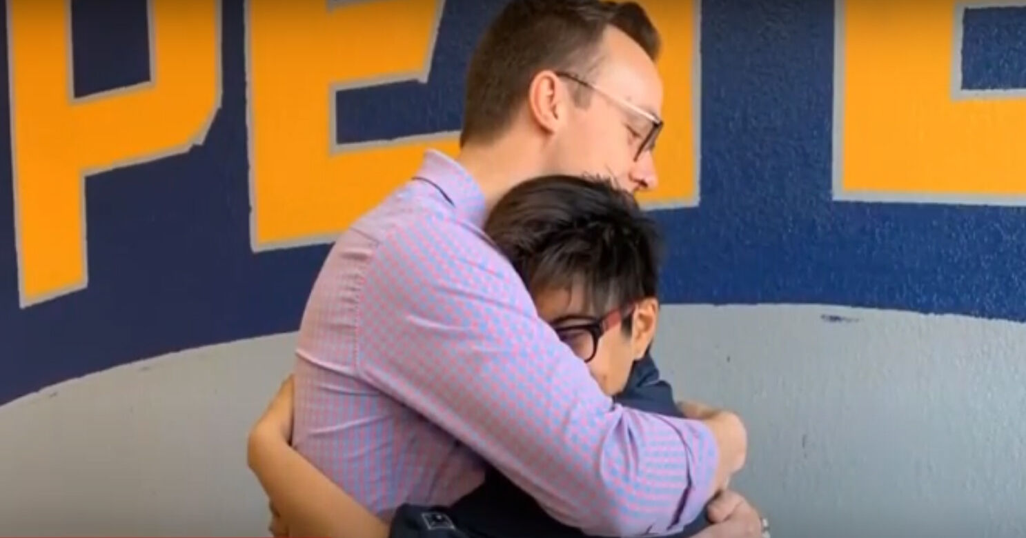 Chasten hugging a boy