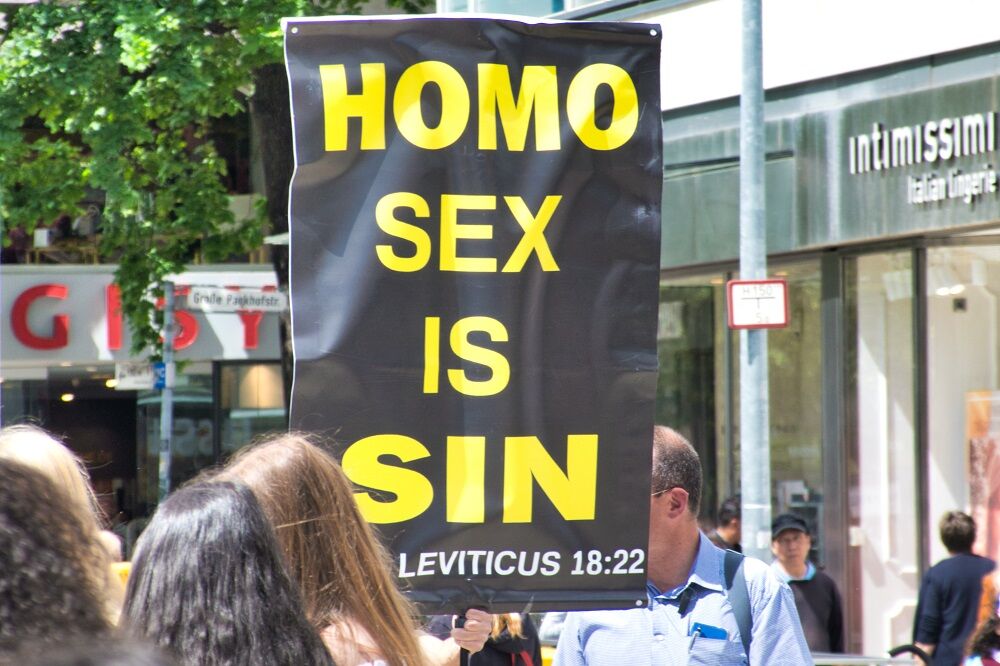 A Christian group protests Pride in Hannover, Germany that says "HOMO SEX IS SIN"