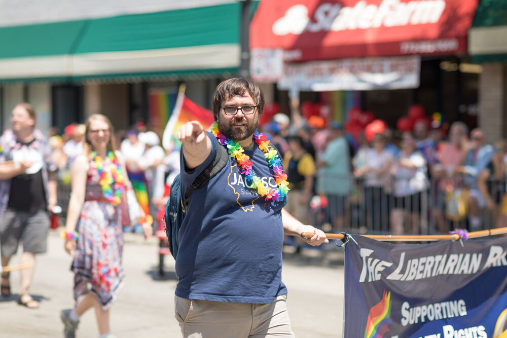 June 24, 2018 Man points at camara holding a banner that says The Libertarian party supporting equality rights gduring the LGBTQ Pride Parade in Chicago