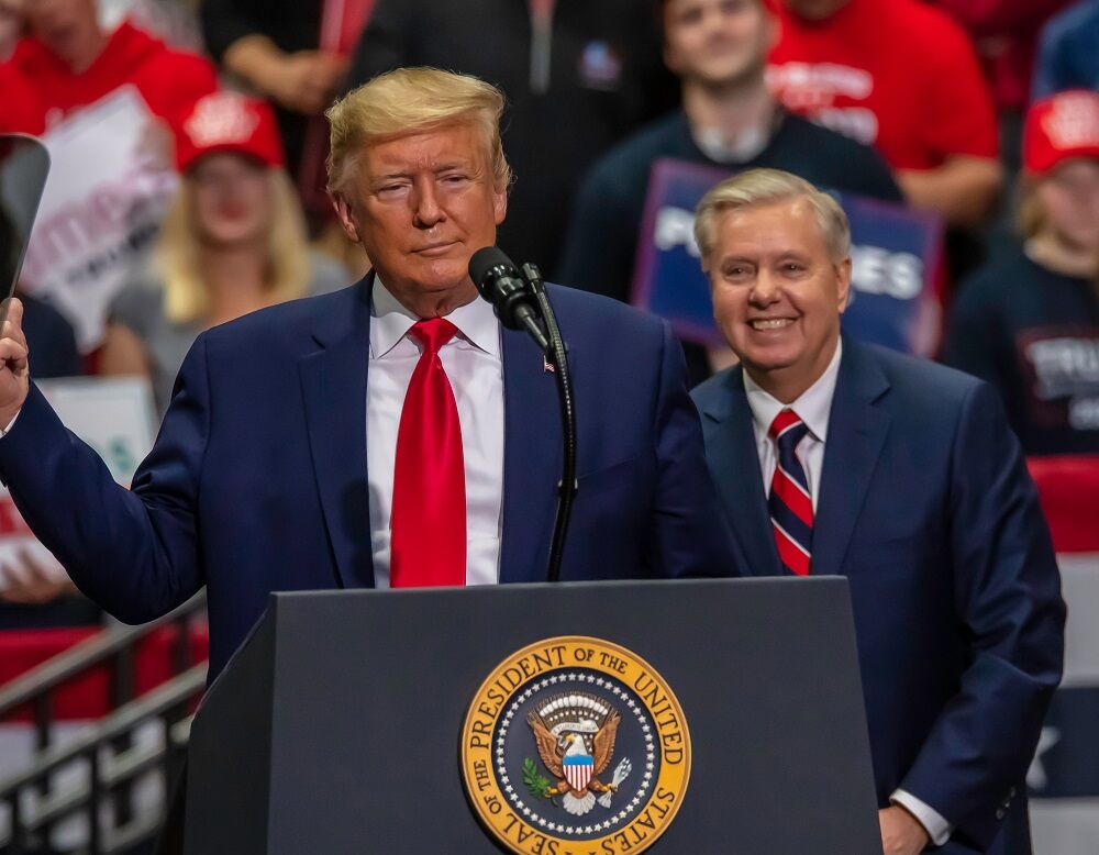 2 March 2020: Senator Lindsey Graham smiles behind President Trump at a North Carolina rally