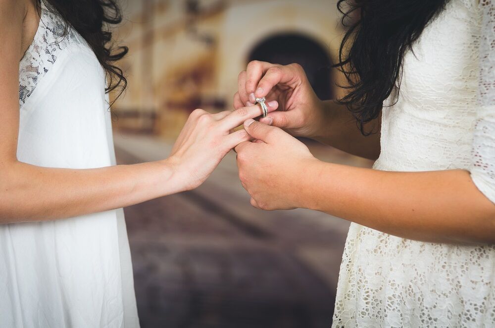 Two women exchanging rings at a wedding
